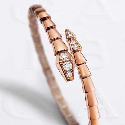 Serpenti Viper 18 kt rose gold bracelet set with demi-pavé diamonds. White Bulgari logo backdrop.