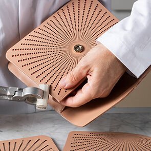 Craftsman finishing the Serpenti Forever Laser cut bag in perforated soft pink calf leather. Craftsman finishing the Serpenti Forever Laser cut bag in perforated soft pink calf leather.