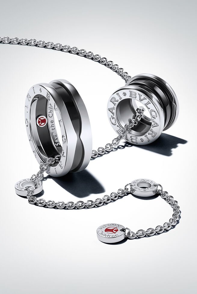 The image shows the Bvlgari Save the Children necklace with pendant and ring, both with the organisation’s logo engraved onto the piece.