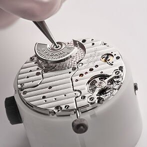 Watchmaker assembling a component of the Octo Finissimo Perpetual Calendar watch's calibre, close-up.