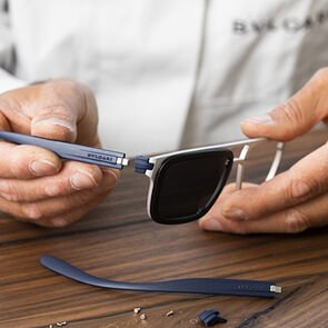 Craftsman assembling the temples of the Bulgari Aluminium sunglasses, using tools, close up. Craftsman assembling the temples of the Bulgari Aluminium sunglasses, using tools, close up.