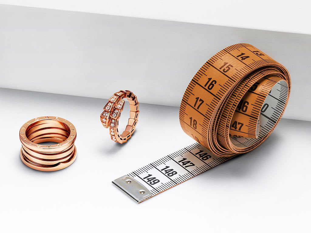 B.zero1 rose gold and black ceramic ring with pavé diamonds, Serpenti Viper rose gold ring with pavé diamonds, tape measure and Bvlgari Ring Sizer.