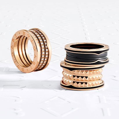 B.zero1 three-band rings with diamonds, black ceramic and studs, against a white Bulgari logo backdrop.