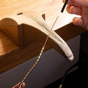 Artisan finishing the metallic scale-motif temples of the Serpenti Viper glasses, close-up.