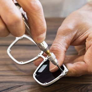 Craftsman assembling the lenses of the Bulgari Aluminium sunglasses, using tools, close up. Craftsman assembling the lenses of the Bulgari Aluminium sunglasses, using tools, close up.