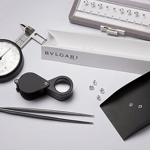 Bulgari craftsman mounting a diamond into the setting of an engagement ring, close up of the hands.
