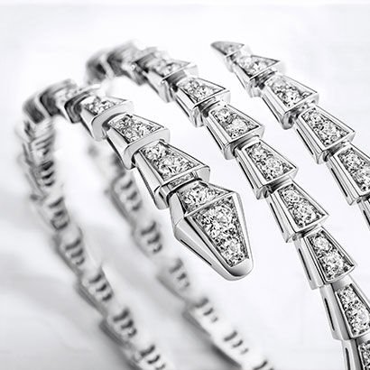 Serpenti Viper two-coil 18 kt white gold bracelet set with pavé diamonds. White Bulgari logo backdrop.