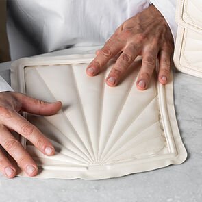 Craftsman holding a calf leather panel with quilted radial motif of the Serpenti Diamond Blast sunshine bag.