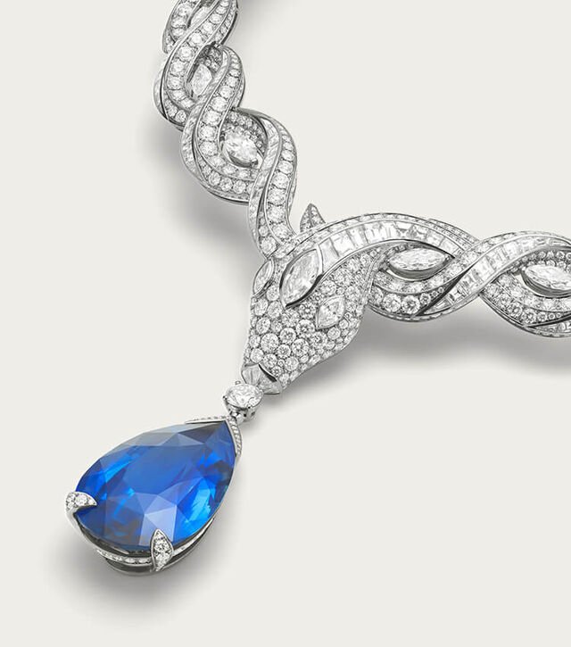 Serpenti Eden High Jewellery platinum necklace with sapphire and diamonds, Bulgari logo backdrop.