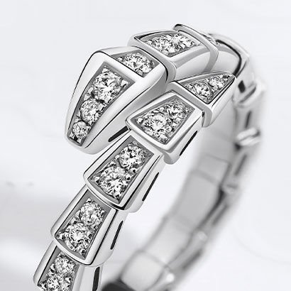 Serpenti Viper single-coil ring in white gold fully set with diamonds, against a white background.