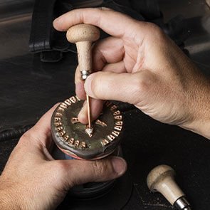 Craftsman setting a diamond into the rose gold scale of the Serpenti Viper collection, close-up. Craftsman setting a diamond into the rose gold scale of the Serpenti Viper collection, close-up.