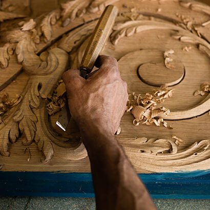 Artisan recreating the wooden door of Bulgari's Place Vendôme store, faithful to the original, close up.