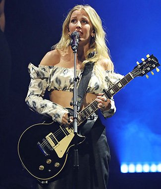 Ellie Goulding handling a guitar during the night