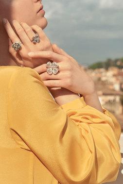 a model dressed in yellow wearing three rings