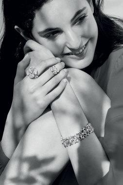 A close up of a model wearing a bracelet and two rings